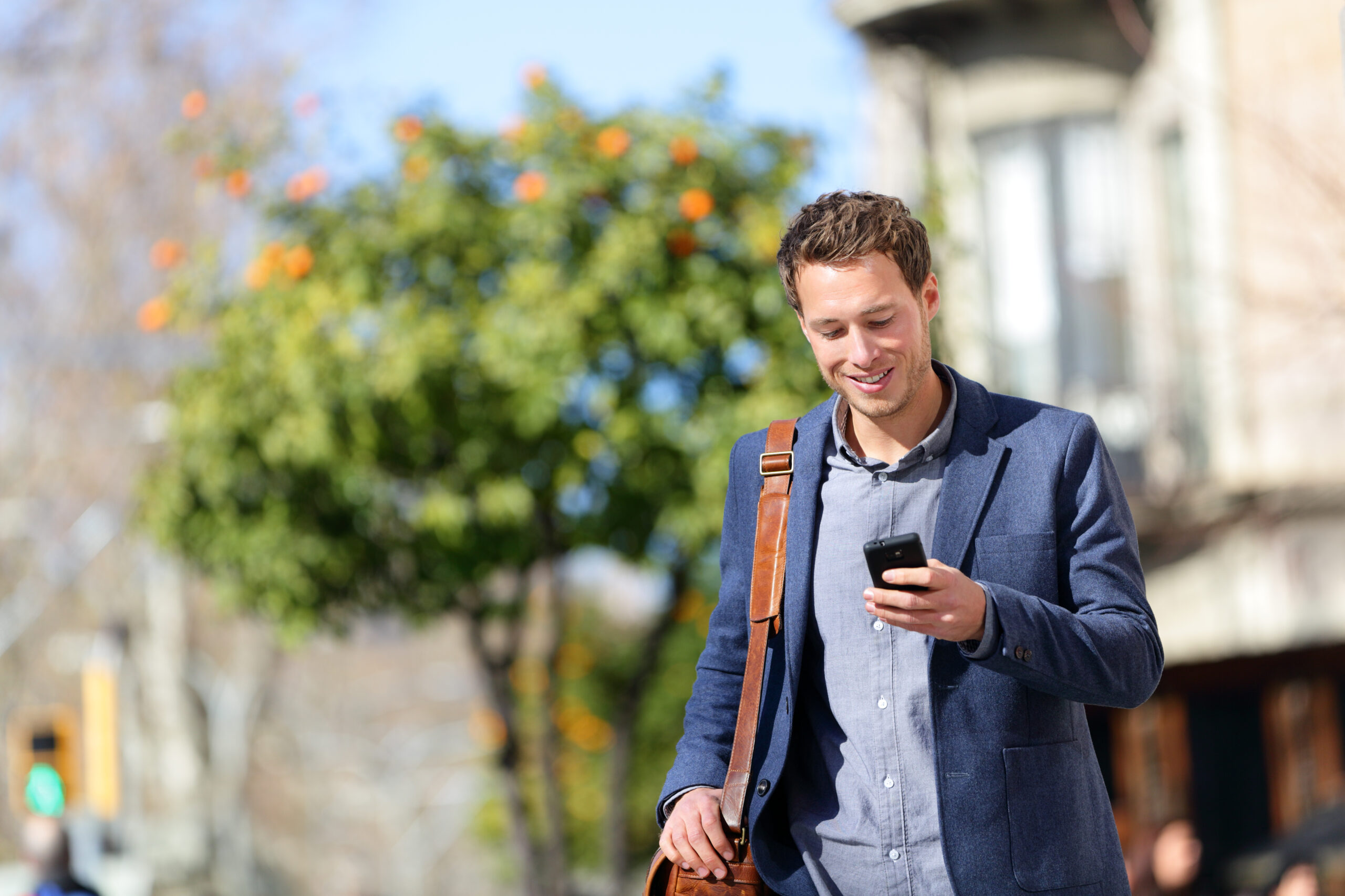 Young professional outside looking at his phone